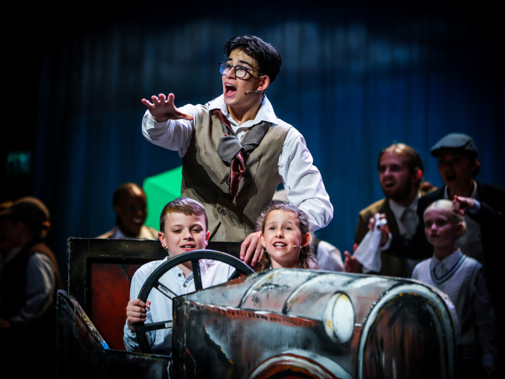 Stagecoach students in costume performing a scene in a vintage car on stage