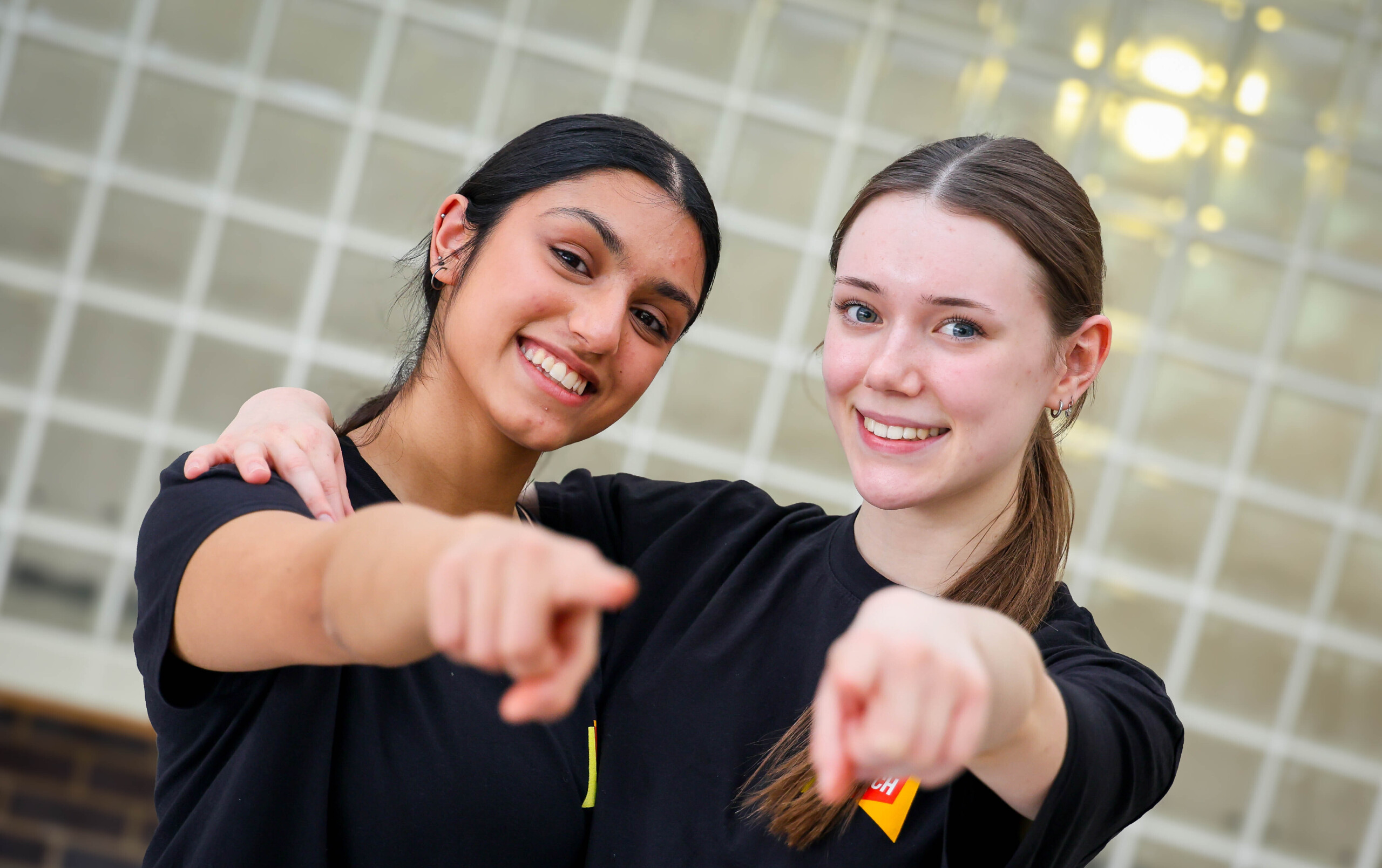 Two smiling Further Stages students pointing during a dance routine